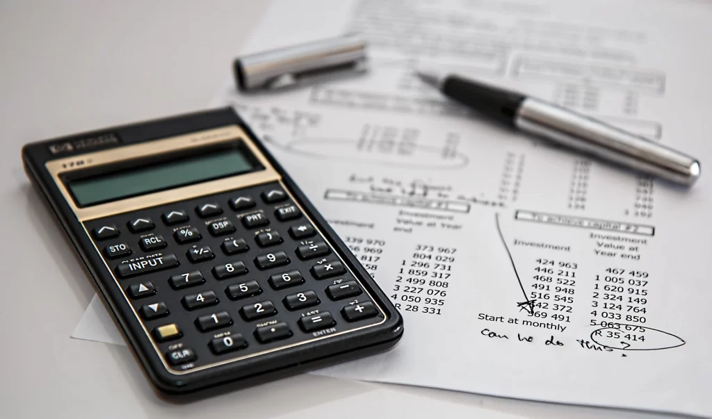 Financial calculator and documents representing tax-efficient wealth structuring. Planning the cost-benefit analysis of a labuan trust for high-net-worth clients in singapore, jakarta, bangkok, and kuala lumpur.