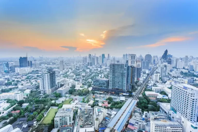 Aerial view of the bangkok, thailand skyline and bts skytrain at sunset, representing the growing asian market for offshore trusts and estate planning services offered by cnb trustee.