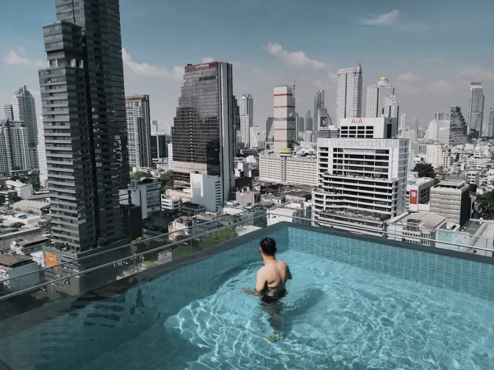 The 2025 outlook - strategic tax planning for thai hnwis - cnb trustee, your trusted partner in legacy advisory and will writing services. A high-net-worth individual overlooking the bangkok skyline from a rooftop infinity pool, representing the strategic foresight and financial freedom provided by an offshore labuan family office.