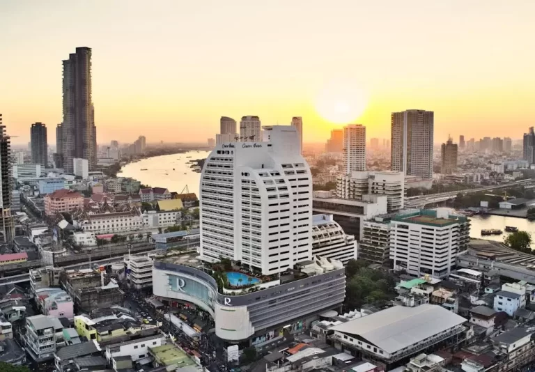 วิวแม่น้ำเจ้าพระยาและตึกระฟ้าในกรุงเทพฯ ยามเย็น แสดงถึงศูนย์กลางธุรกิจและความมั่งคั่งของไทย