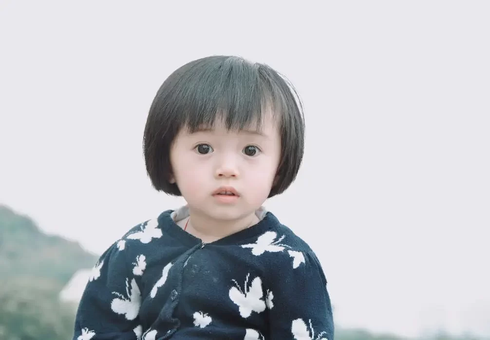 Mm2h dependent visa for singaporean families - cnb trustee, your trusted partner in legacy advisory and will writing services. A portrait of a young child wearing a blue butterfly-patterned cardigan, representing mm2h dependents.